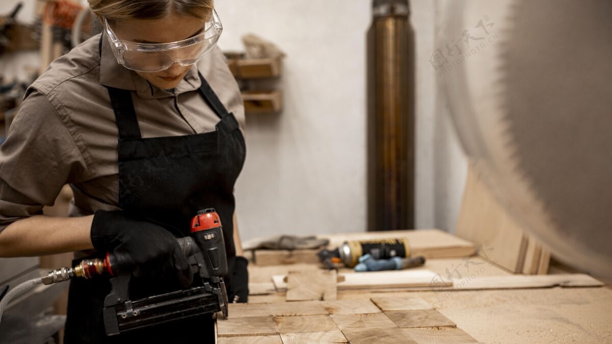 女性带气动订书机的女木匠侧视图职业工作技能