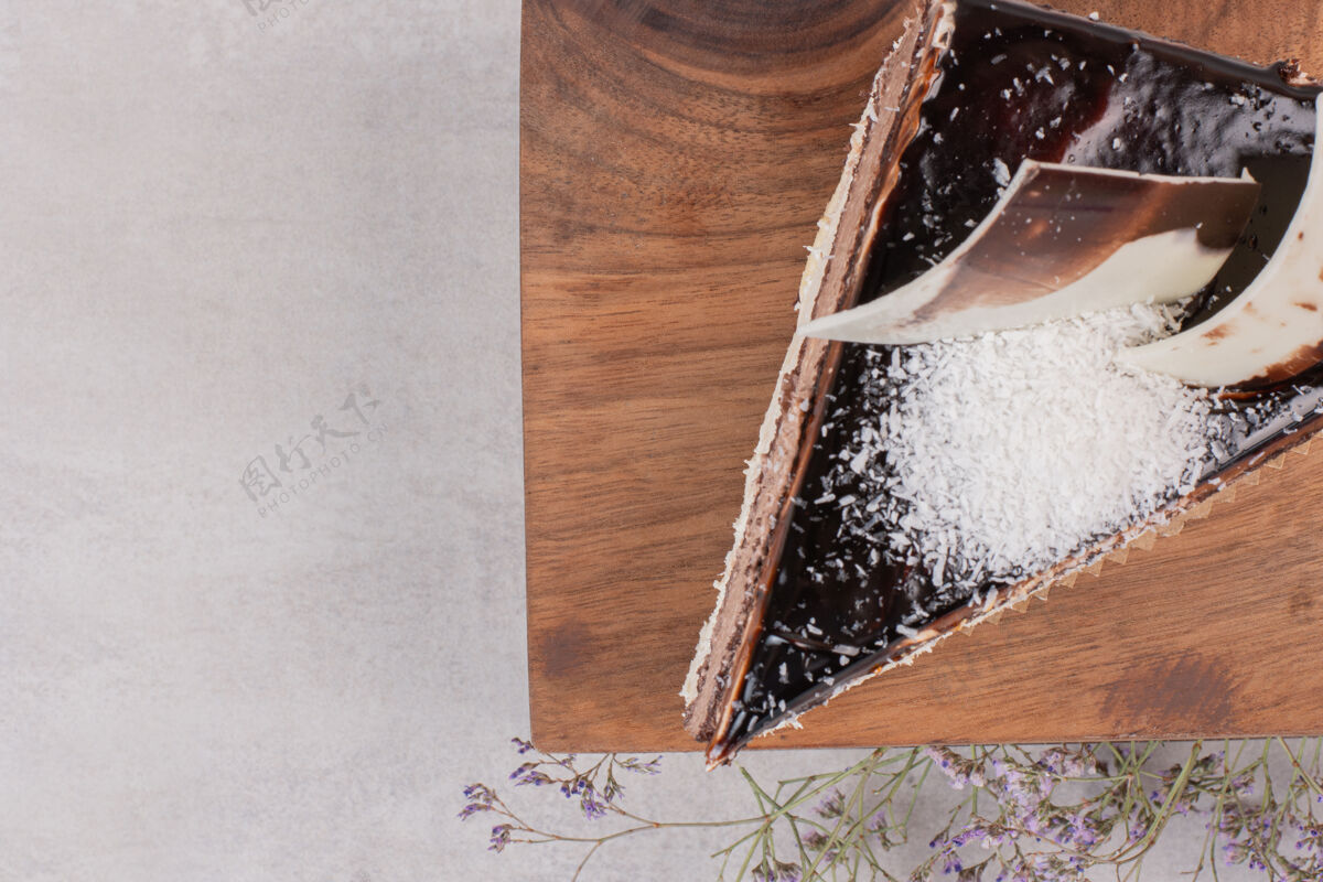 糖在木板上切一片巧克力蛋糕美味奶油顶部