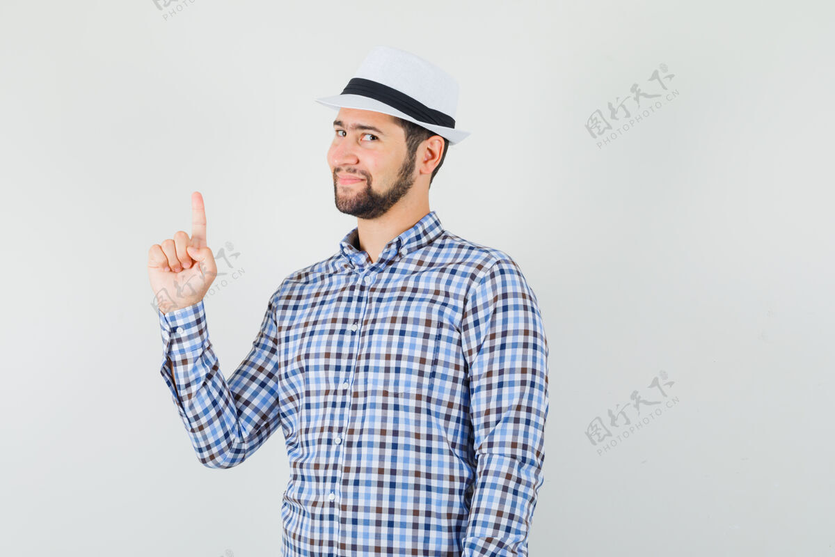发型一个穿着格子衬衫 戴着帽子 看上去很懂事的年轻人胡须成功交叉