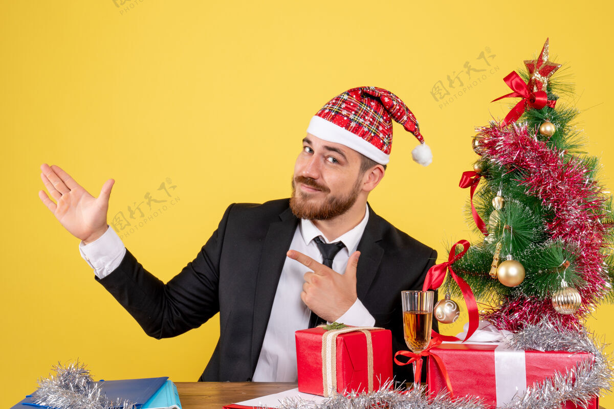专业正面图：坐在黄色工作台后面的男工人地点工作圣诞节