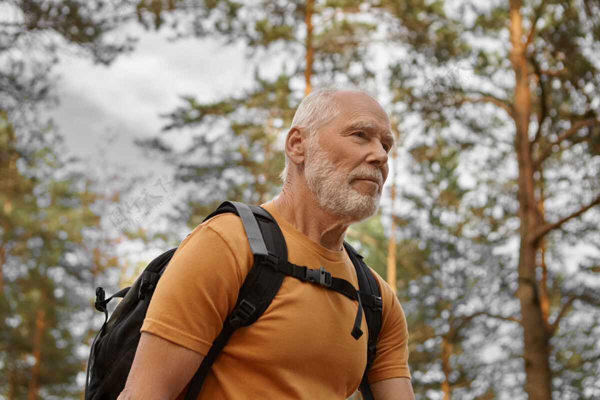 老年人快乐胡须的白人男性旅行者独自背包的特写图片 有活力的外观时尚活跃的男性背包客背包徒步旅行 享受健康的生活方式和有氧运动活动目的地户外