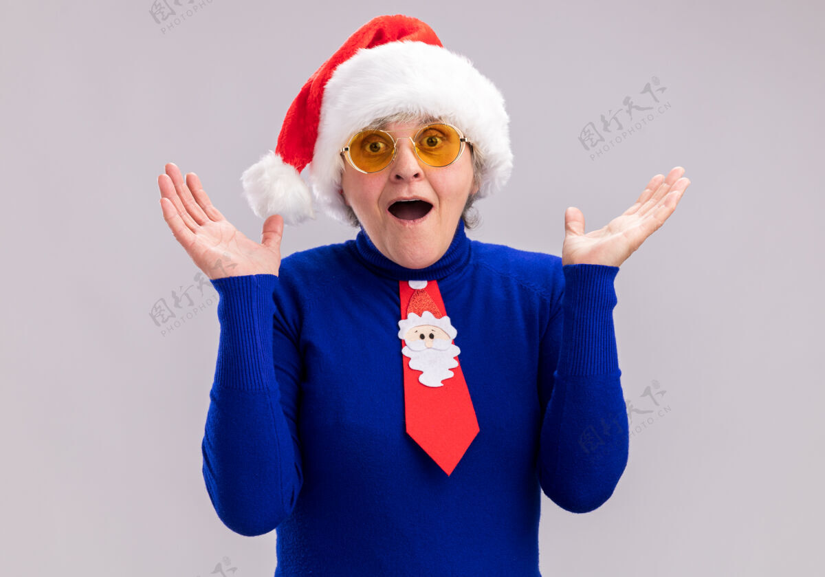 惊讶一位戴着太阳眼镜 戴着圣诞帽 系着圣诞领带的老太太大吃一惊新年老人一年