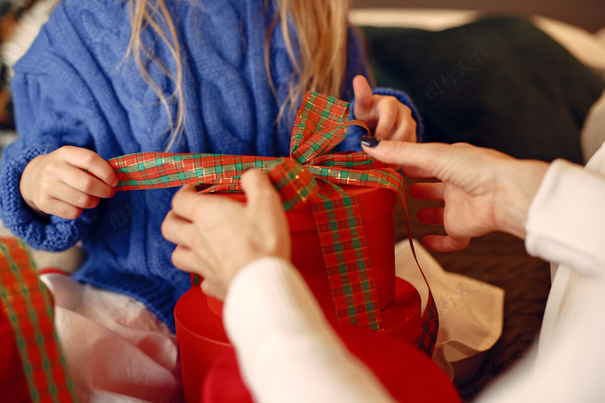 快乐人们在为圣诞节做准备母亲在和女儿玩耍一家人在节日的房间里休息孩子穿着蓝色毛衣童年节日传统