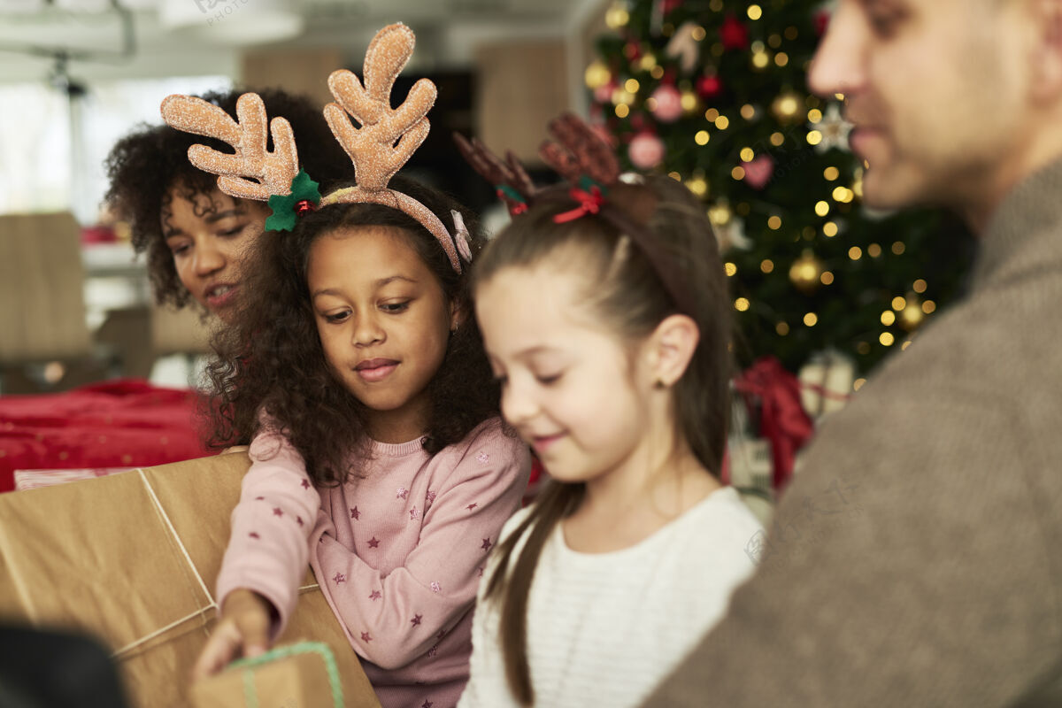 债券孩子们和父母一起打开圣诞礼物家家庭舒适
