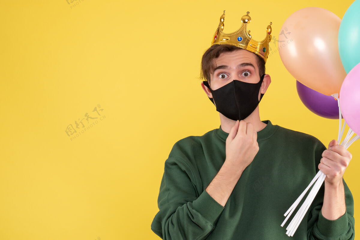 皇冠正面图戴着皇冠和黑色面具的年轻人拿着黄色的气球年轻人黑色封面