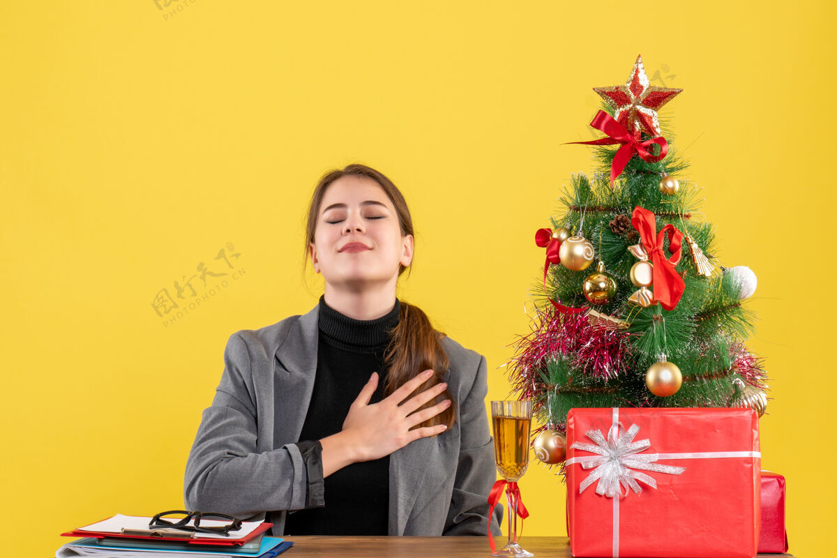 圣诞节前视图安静的女孩坐在桌子旁把手伸过来成人人鸡尾酒