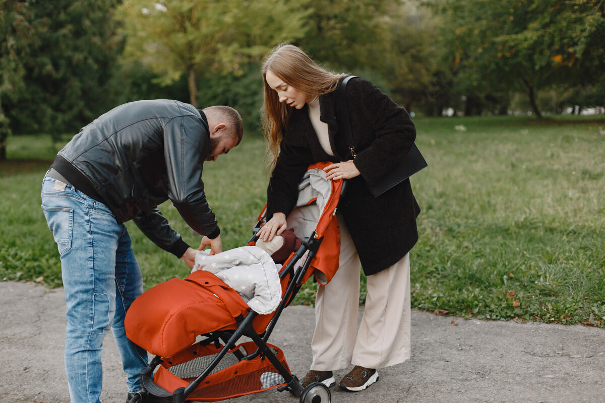 女儿一家人在秋天的公园里男人穿着黑色夹克可爱的小女孩和父母头发户外家庭