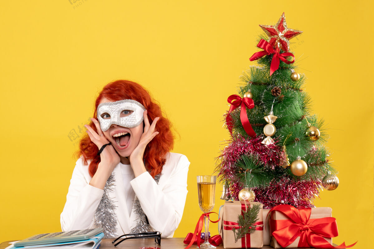 表演者女医生戴着面具围着圣诞树 黄色的礼物周围女性圣诞树