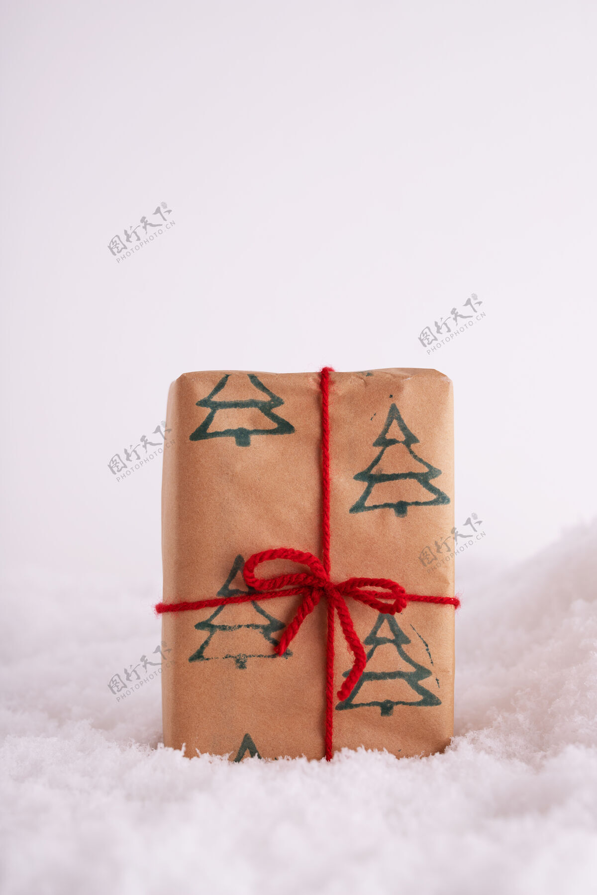 礼物圣诞树图案和雪地红丝带礼盒垂直白雪