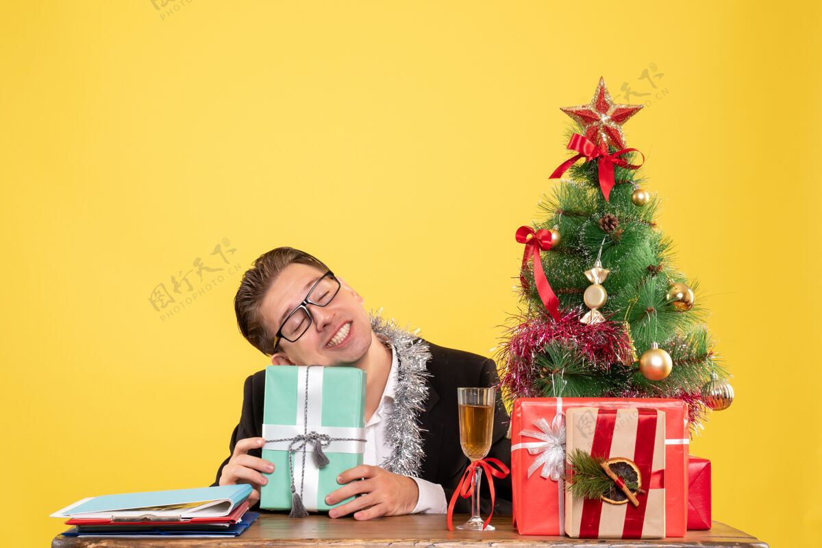 颜色正面图：男工人拿着圣诞礼物和圣诞树坐着人工作礼物