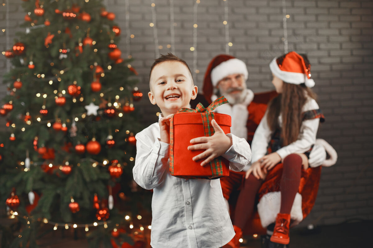 肖像圣诞节 孩子们和礼物圣诞老人给孩子们带来礼物快乐的孩子们带着礼物拥抱圣诞老人庆祝拥抱三