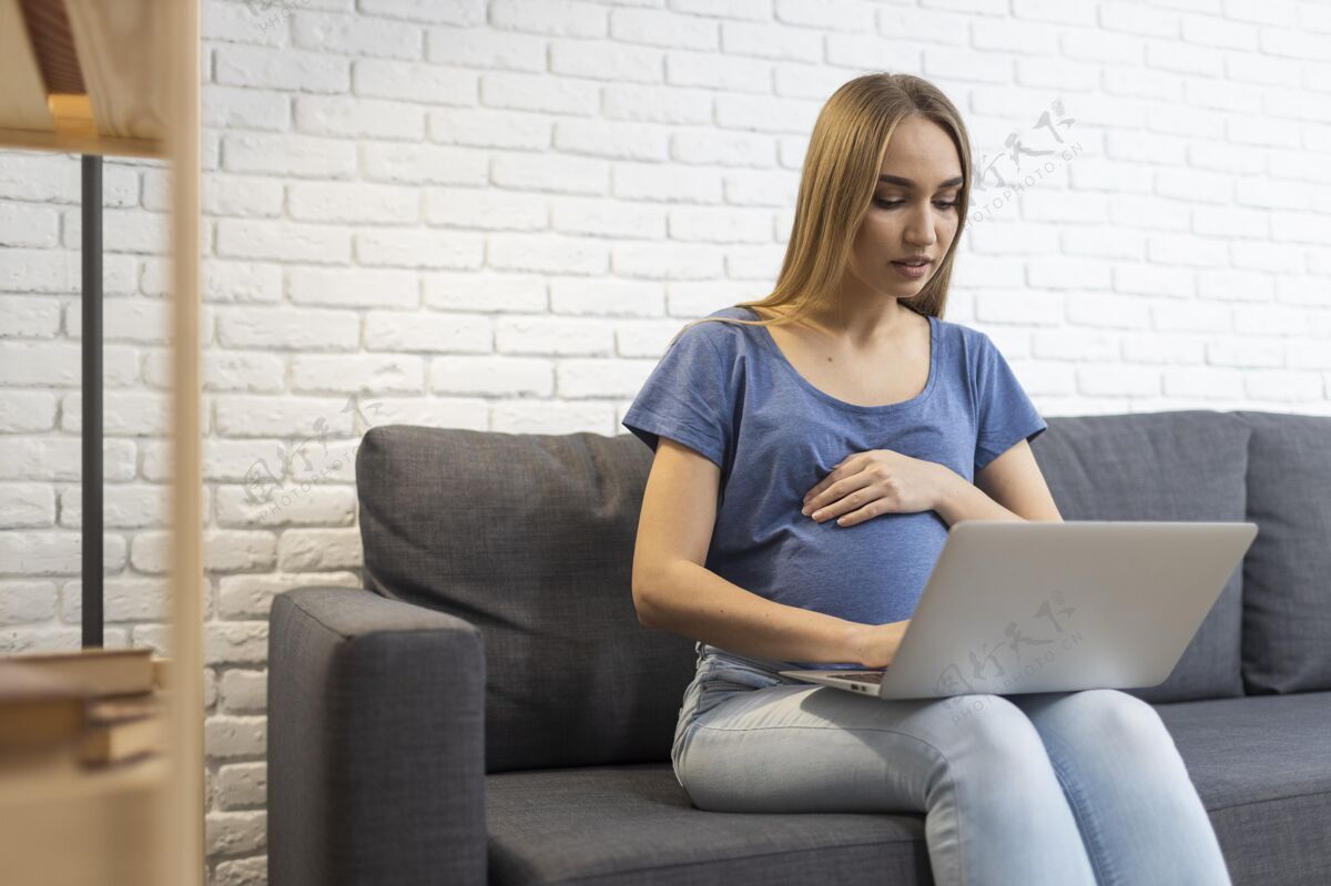 职业坐在沙发上用笔记本电脑工作的孕妇妈妈怀孕职业