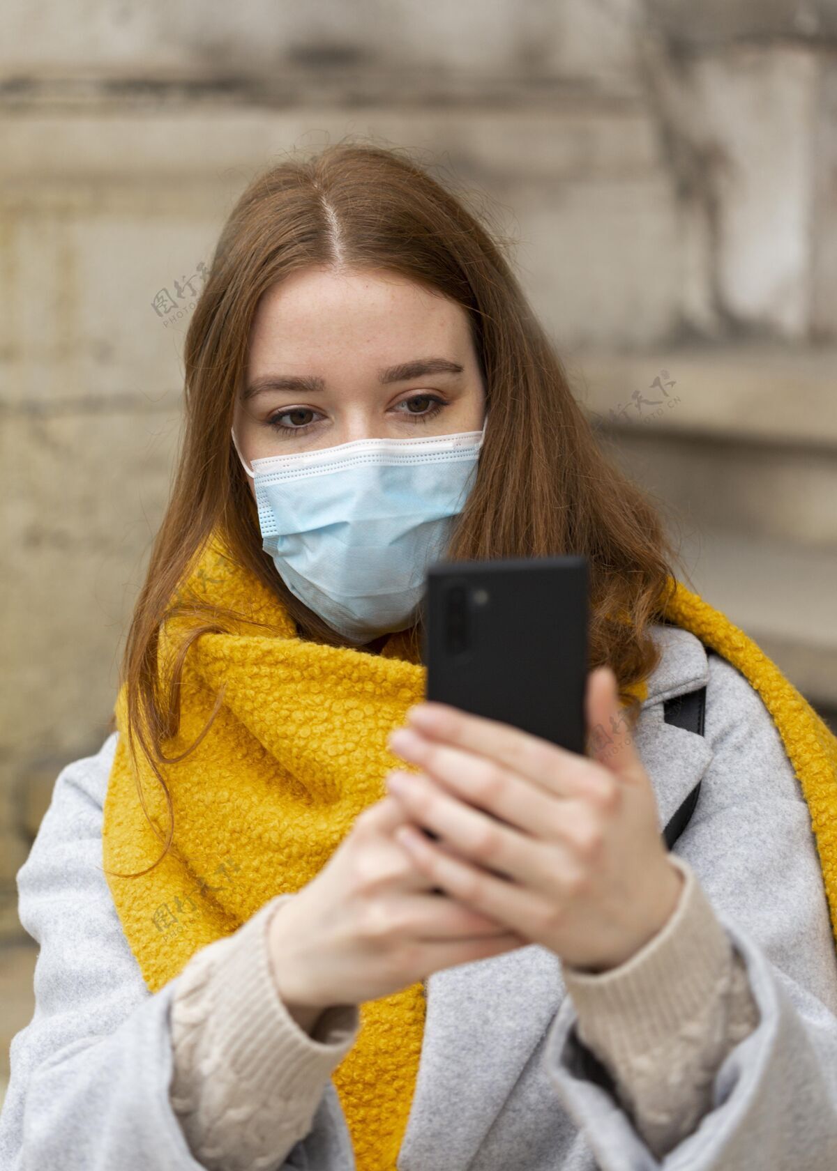 新戴着医用面罩的女士用智能手机拍照的正面图流行病大流行女性