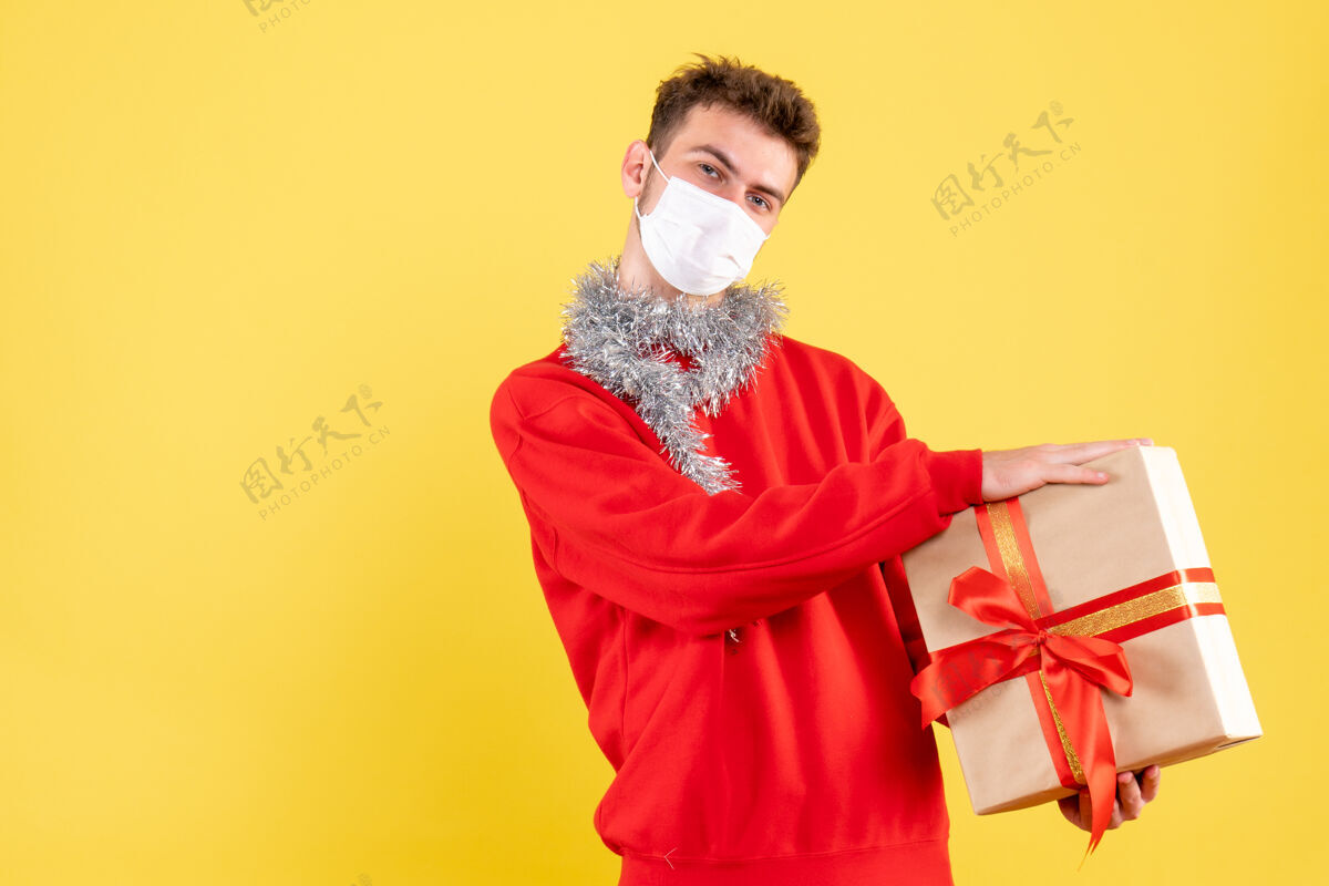 持有正面图：戴着无菌面具的年轻男性正在过圣诞节不育颜色人