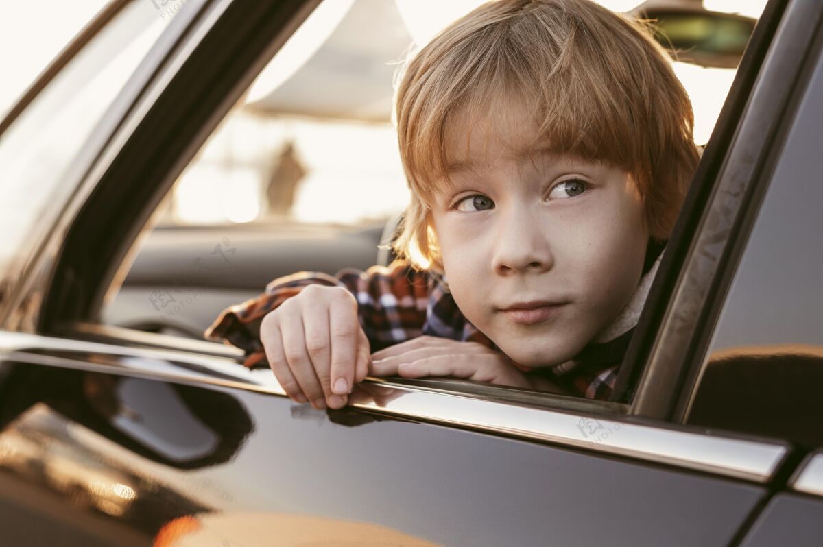 旅行在公路旅行时 一个小孩从车窗向外窥视着他的头孩子旅行冒险