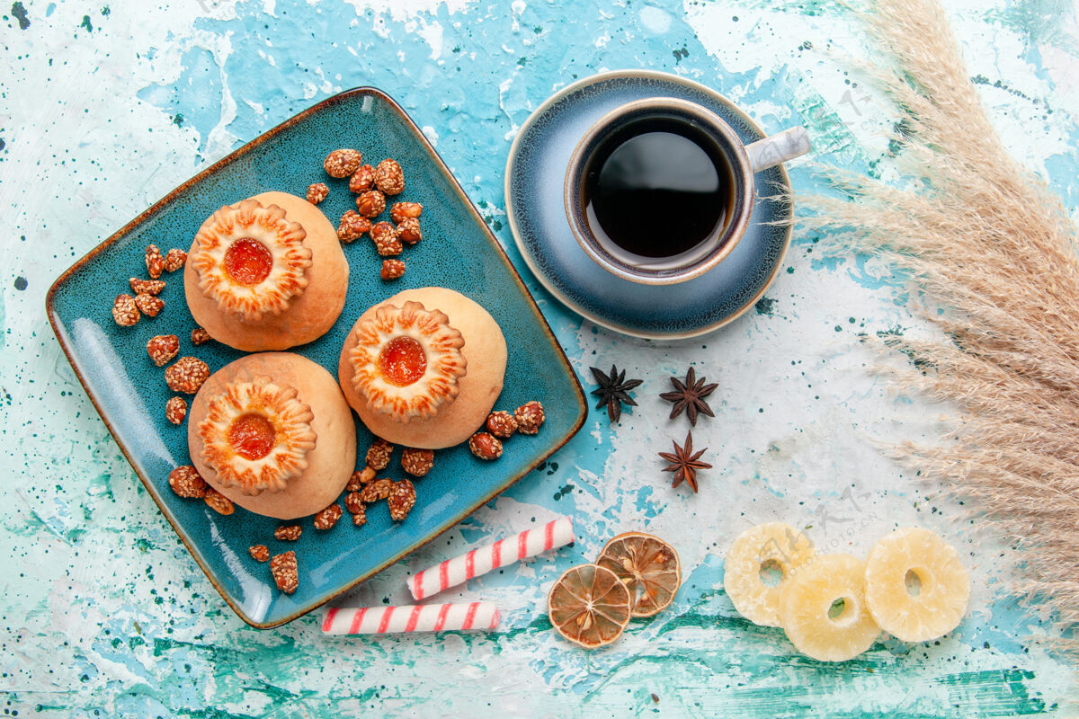饼干俯瞰美味的饼干与干菠萝环和咖啡蓝色表面饼干饼干甜甜的糖的颜色颜色菠萝花