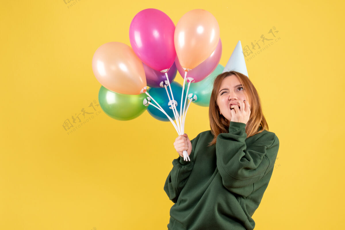 颜色正面图：带着彩色气球的年轻女性气球气球聚会