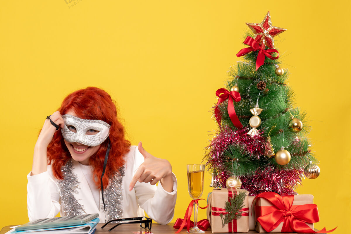 女医生女医生戴着面具围着圣诞树 黄色的礼物书桌穿着情感