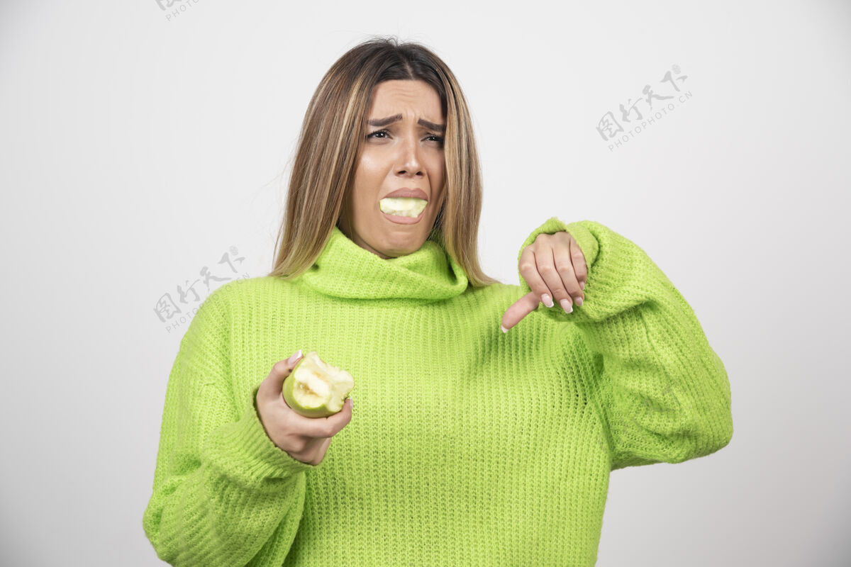 饮食穿着绿色t恤的年轻女子正在吃苹果女性成人表情