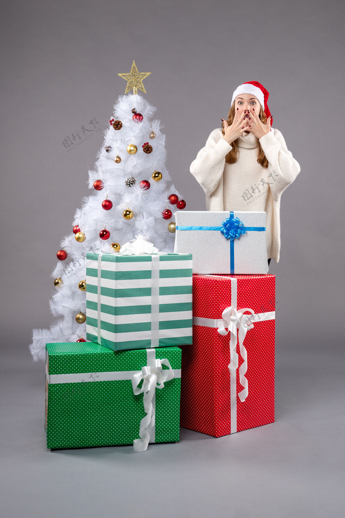 圣诞老人年轻的女性在灰色的礼物年轻圣诞服装