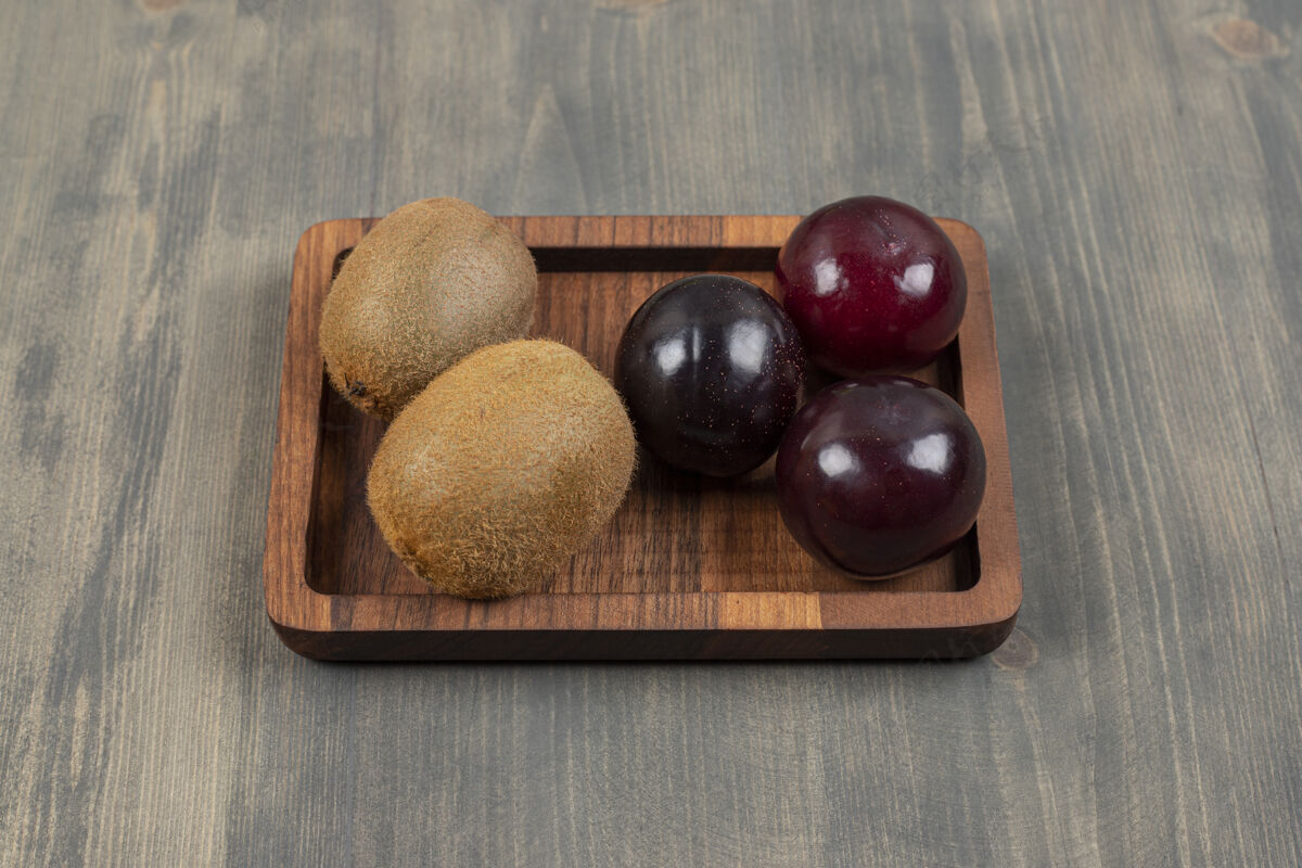 李子多汁的李子和奇异果放在木桌上高质量的照片猕猴桃杂货店矿物质