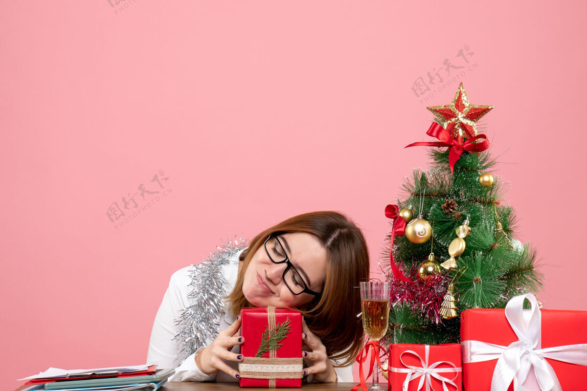 礼物女工坐在粉红色的椅子上 带着圣诞礼物 感觉很累感觉工人成人