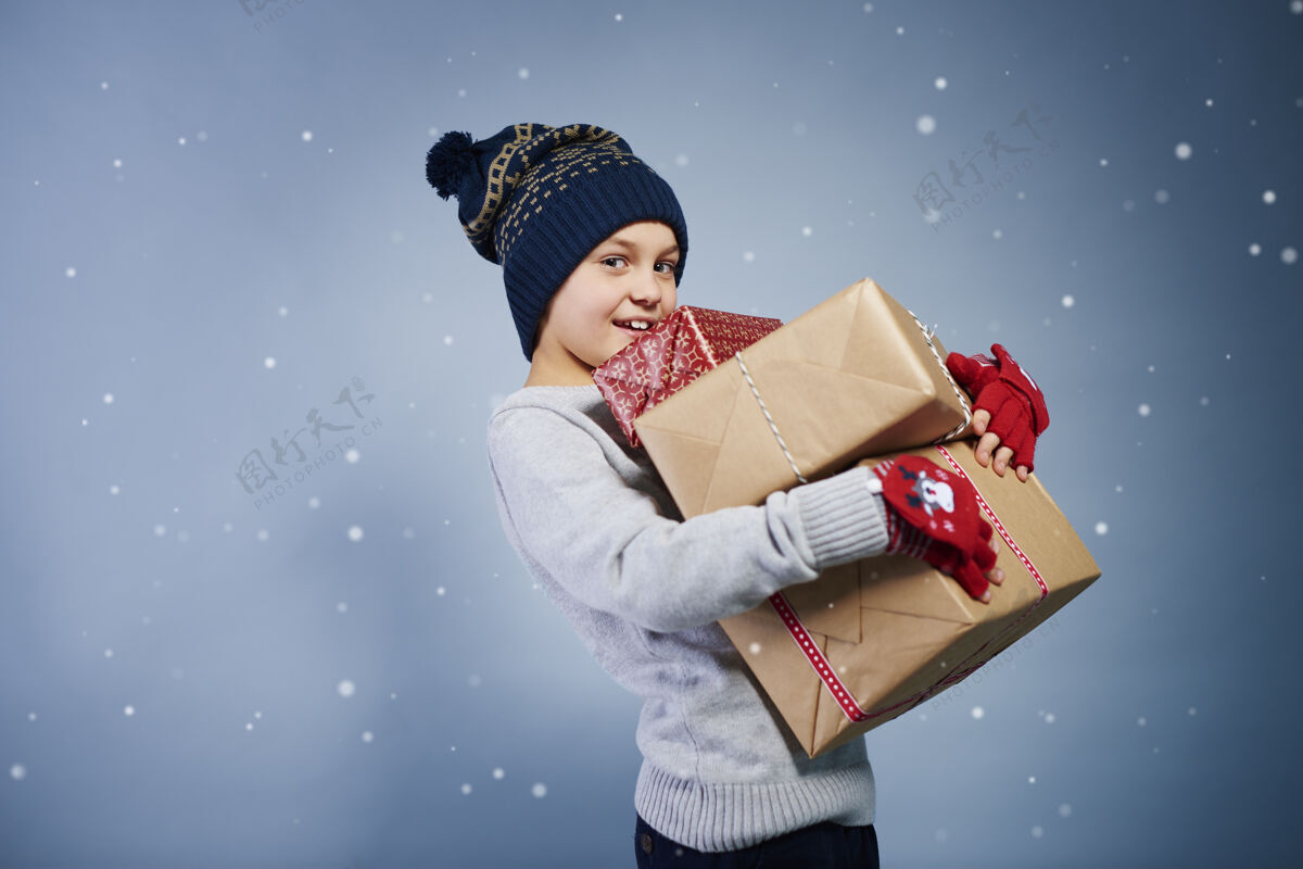 礼物男孩手持圣诞礼物的侧视图帽子纯真盒子