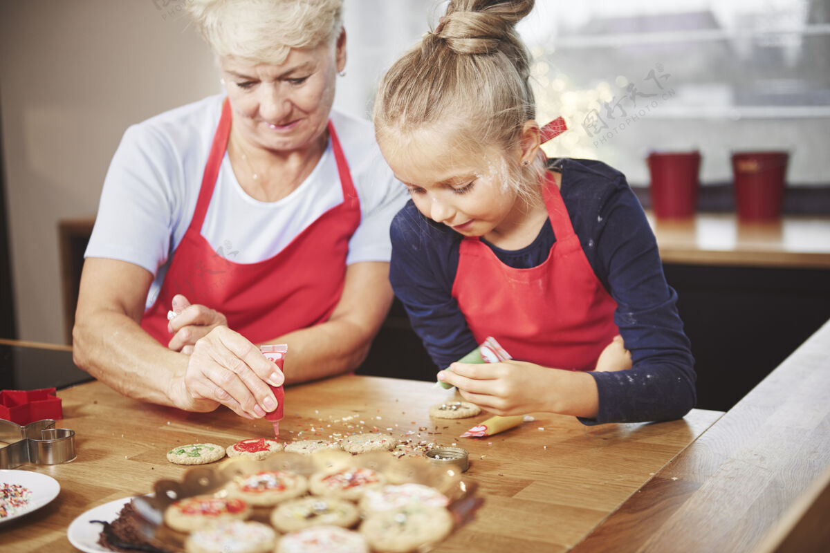 蛋糕孙子和奶奶用糖衣装饰饼干圣诞饼干乐趣圣诞节