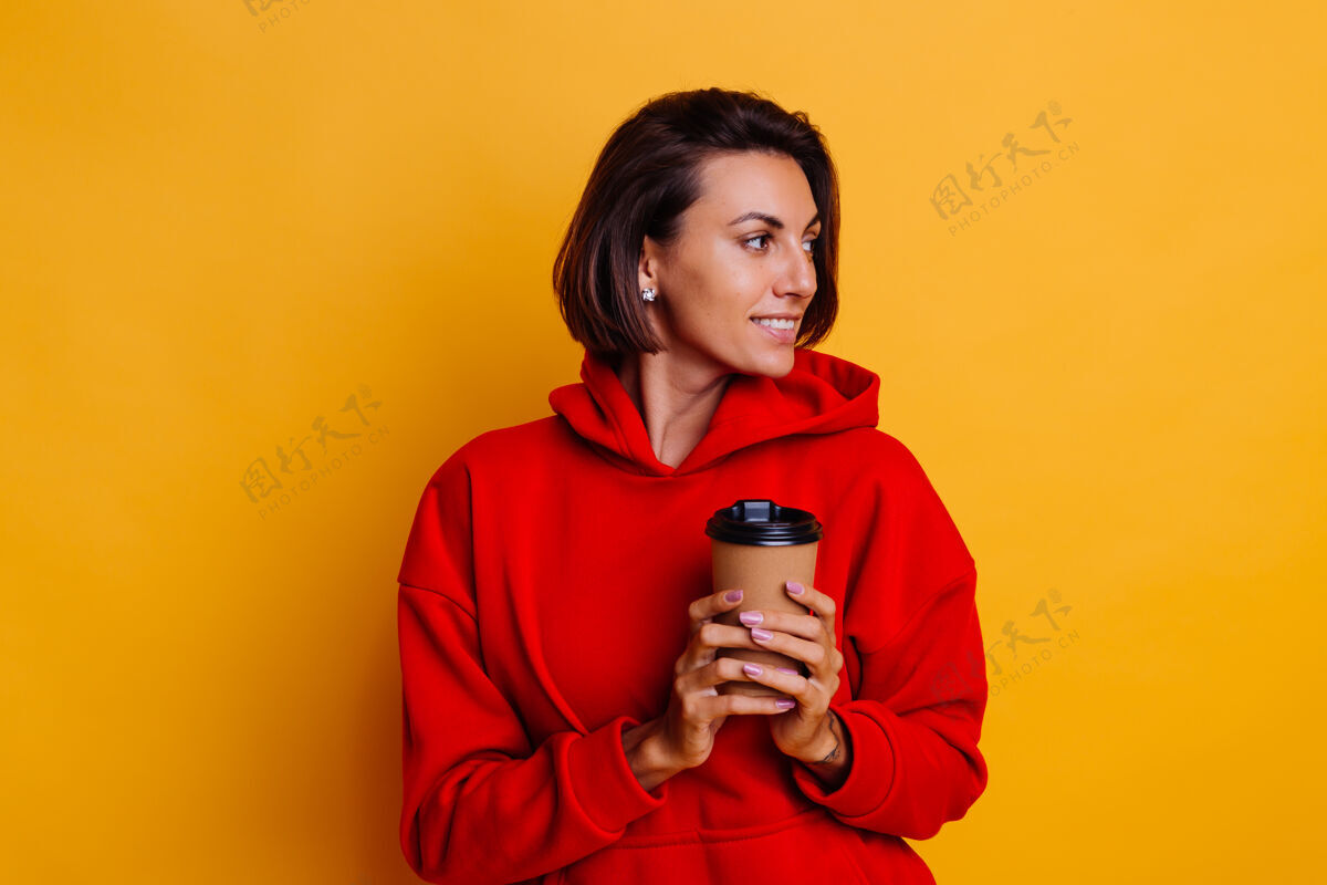 啦啦队快乐的女人穿着暖和的冬衣 用一杯热咖啡取暖肖像穿着乐趣