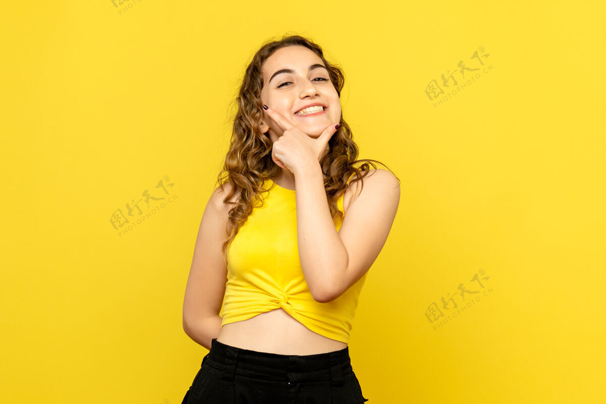 头发黄墙上年轻女子微笑的正面图微笑表情情感