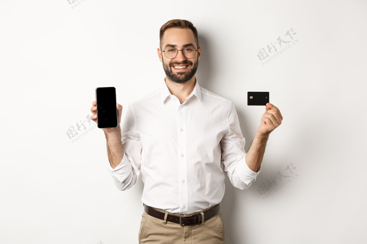 男人商务和网上支付笑容可掬的帅哥展示手机屏幕和信用卡 站着经理买家信用