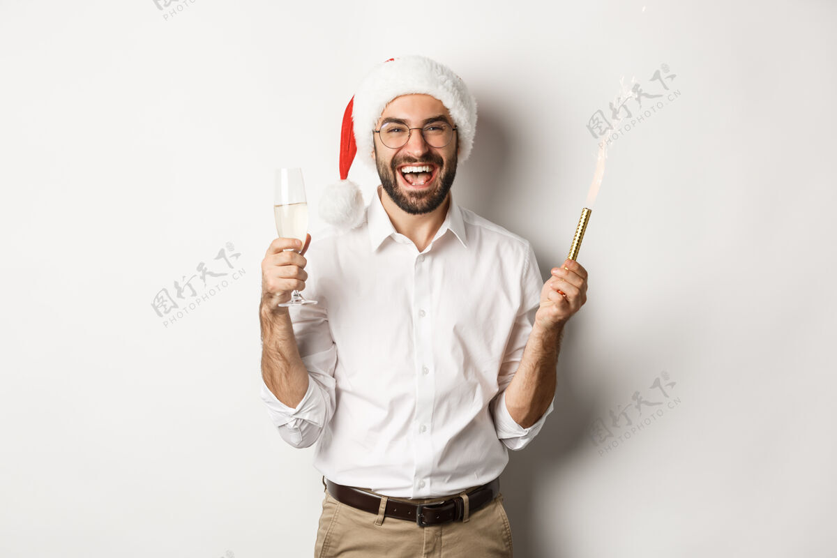 男人寒假和庆祝英俊的胡须男子举行新年聚会 举行焰火和香槟 戴圣诞帽帽子聚会休闲
