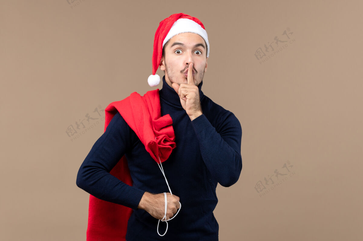 艺人前视图年轻男性要求安静的棕色背景圣诞老人询问男性歌手