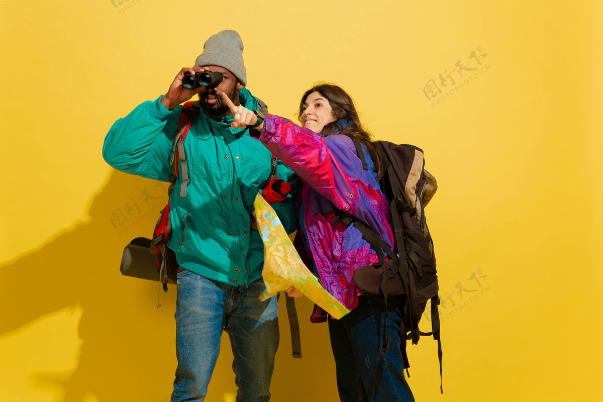 饱满一对快乐的年轻旅游情侣被隔离在黄色的画像明亮衣服长度