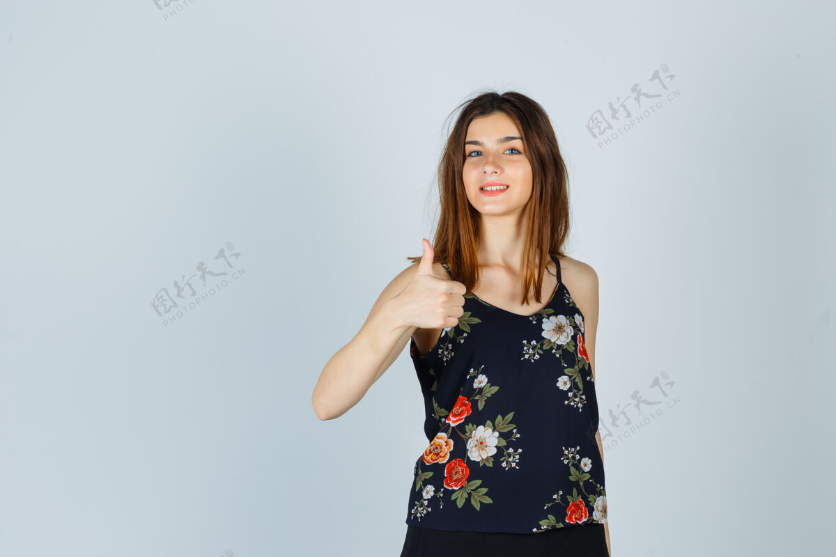 微笑一位年轻漂亮的女士穿着衬衫 竖起大拇指 看上去很快乐女商人女性成人