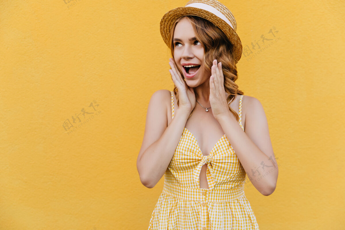 配件优雅的女孩戴着草帽 戴着项链 脸上露出惊讶的微笑穿着黄色连衣裙的卷发女人站在那里夏天时尚休闲