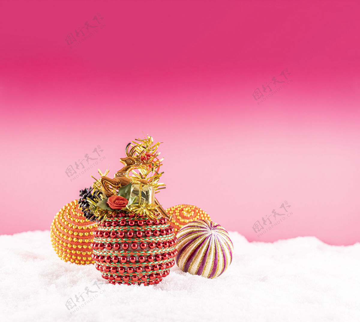 雪在粉红色的背景上 雪地上有彩色玩具的圣诞节新冬天霜冻
