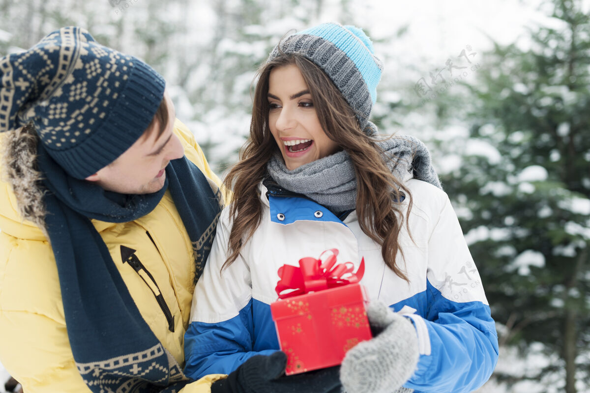 情侣男人在冬天送她女朋友红色礼物乐趣约会温暖的衣服