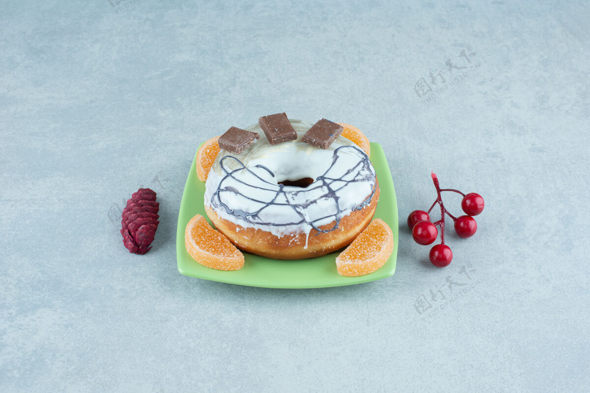 商品在大理石上的圣诞装饰品旁边放着一个小盘子 上面有甜甜圈和marmelades圣诞节上釉拼盘