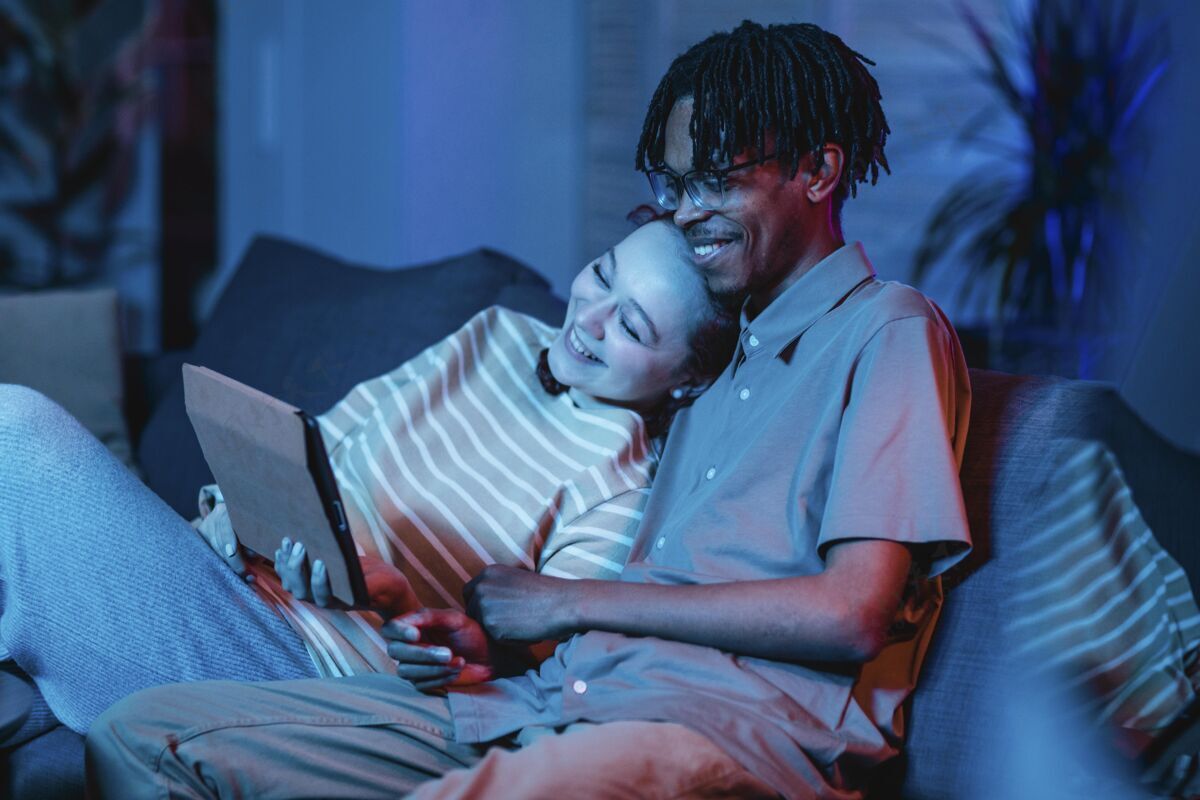 电子笑脸情侣在沙发上用平板电脑科技人人
