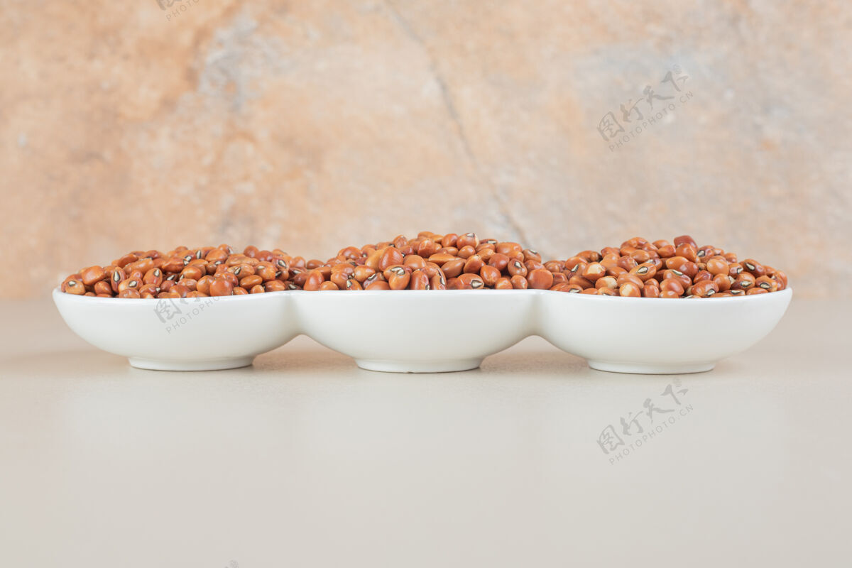 生的咖啡豆被隔离在水泥上的陶瓷杯里有机质量美味