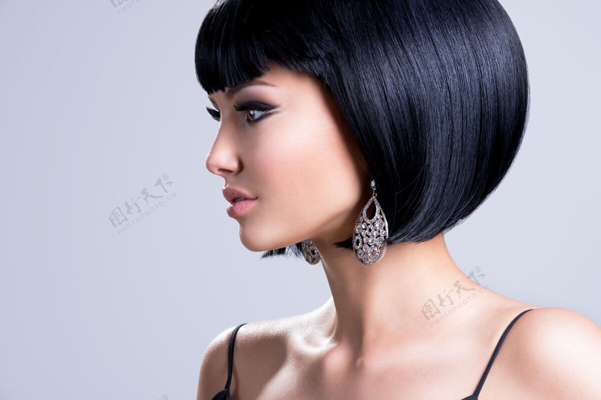 华丽一个美丽的女人与拍摄发型和时尚耳环摆姿势的个人资料肖像发型黑发直