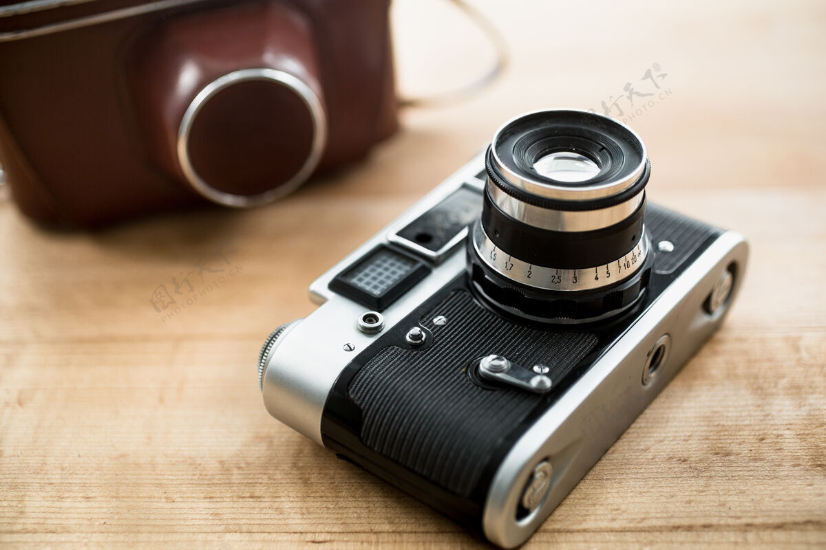 古董复古手动相机和放在桌子上的皮箱的宏观视图模拟相机设备