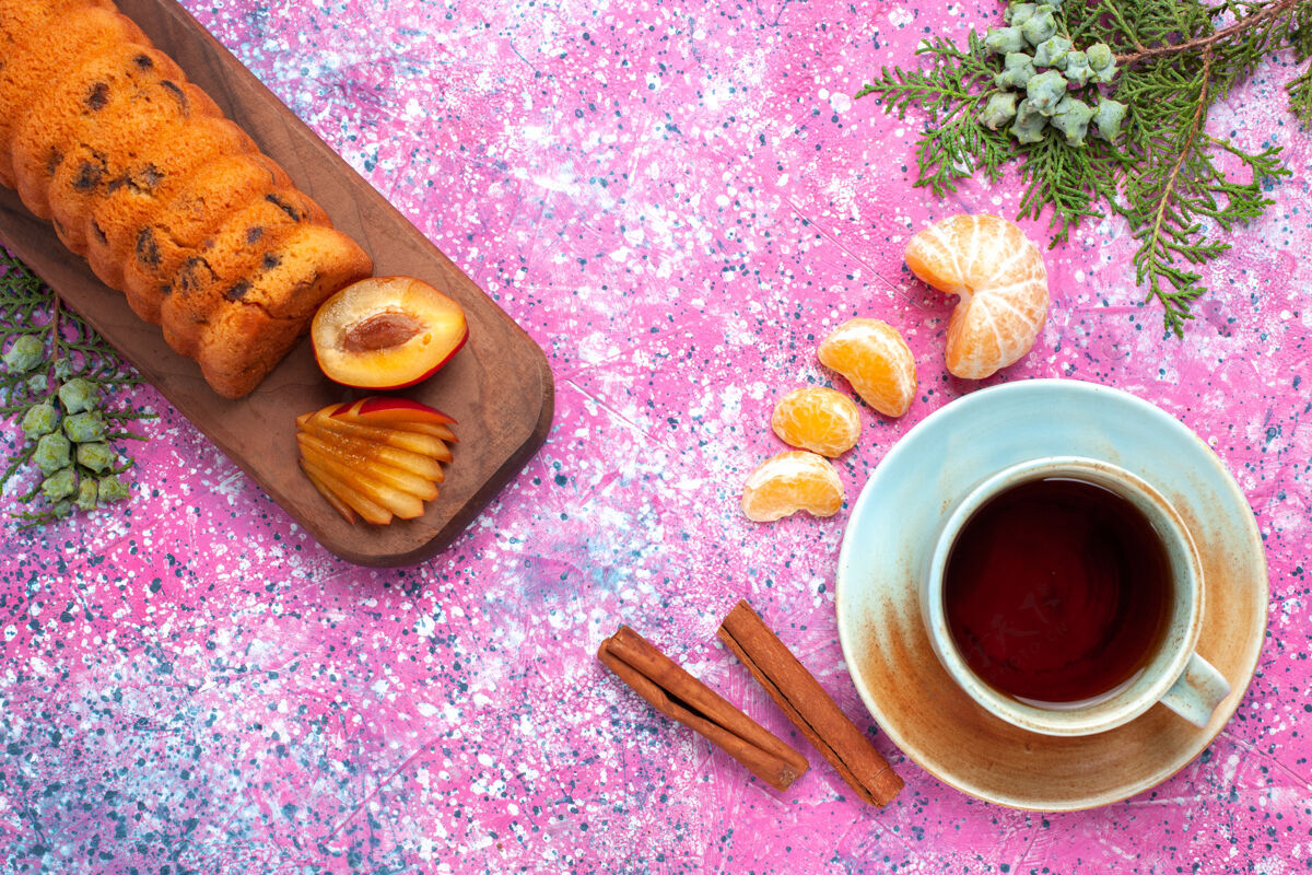 橘子顶视图美味的蛋糕甜和美味的李子茶橘子在粉红色的桌子上茶碟李子甜点