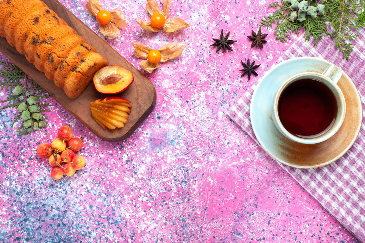 饼干俯瞰美味的蛋糕 甜甜可口 粉色桌上放着李子茶和甜樱桃美味饮料杯子