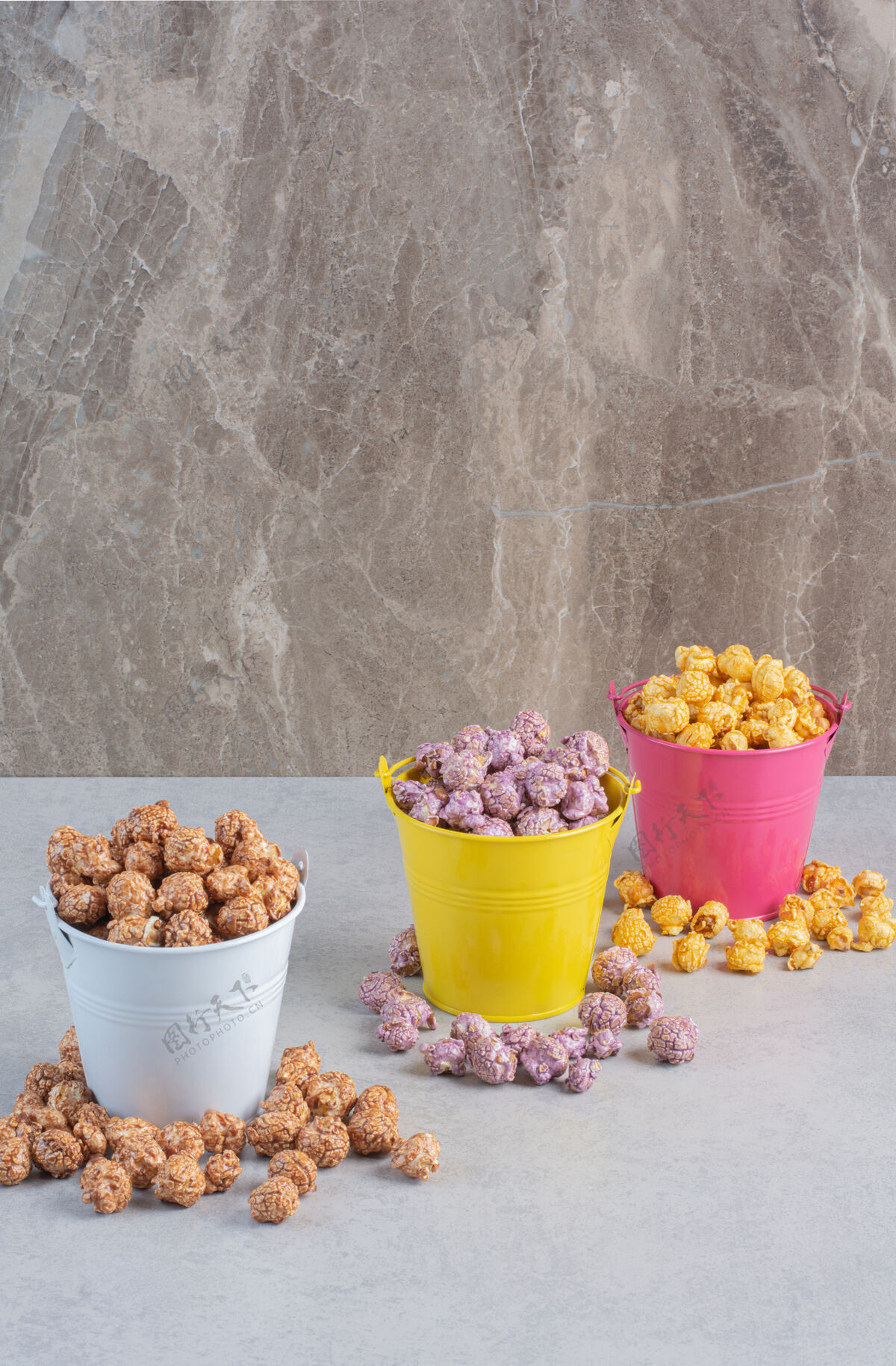 糖果的不同口味和颜色的爆米花糖被放在大理石上的五颜六色的桶里松脆的食品爆米花