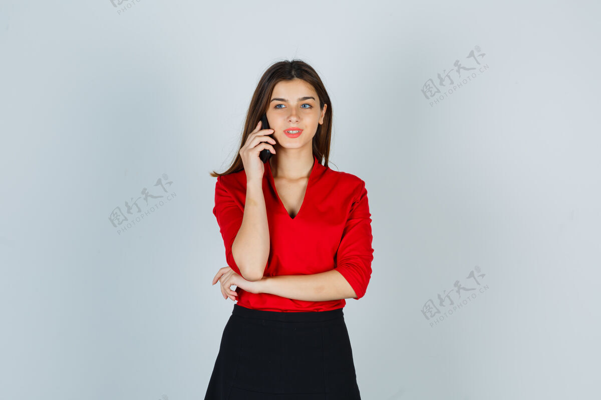 手机穿红衬衫的年轻女士 穿着裙子讲着手机 看起来很开心时尚休闲人