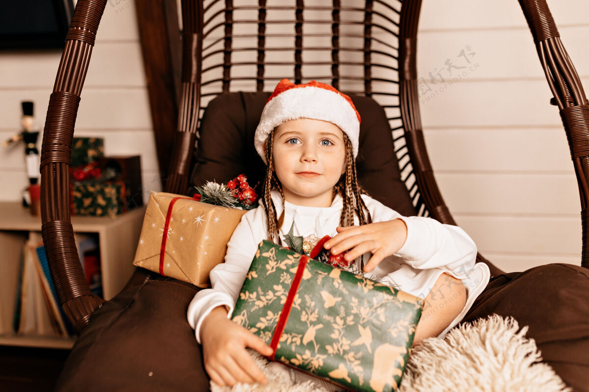 微笑有圣诞礼物的快乐女孩盒子椅子礼物