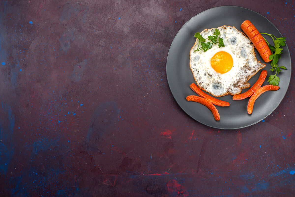 炒菜顶视图炒鸡蛋与绿色和香肠内板在黑暗的表面烹饪桌子锅
