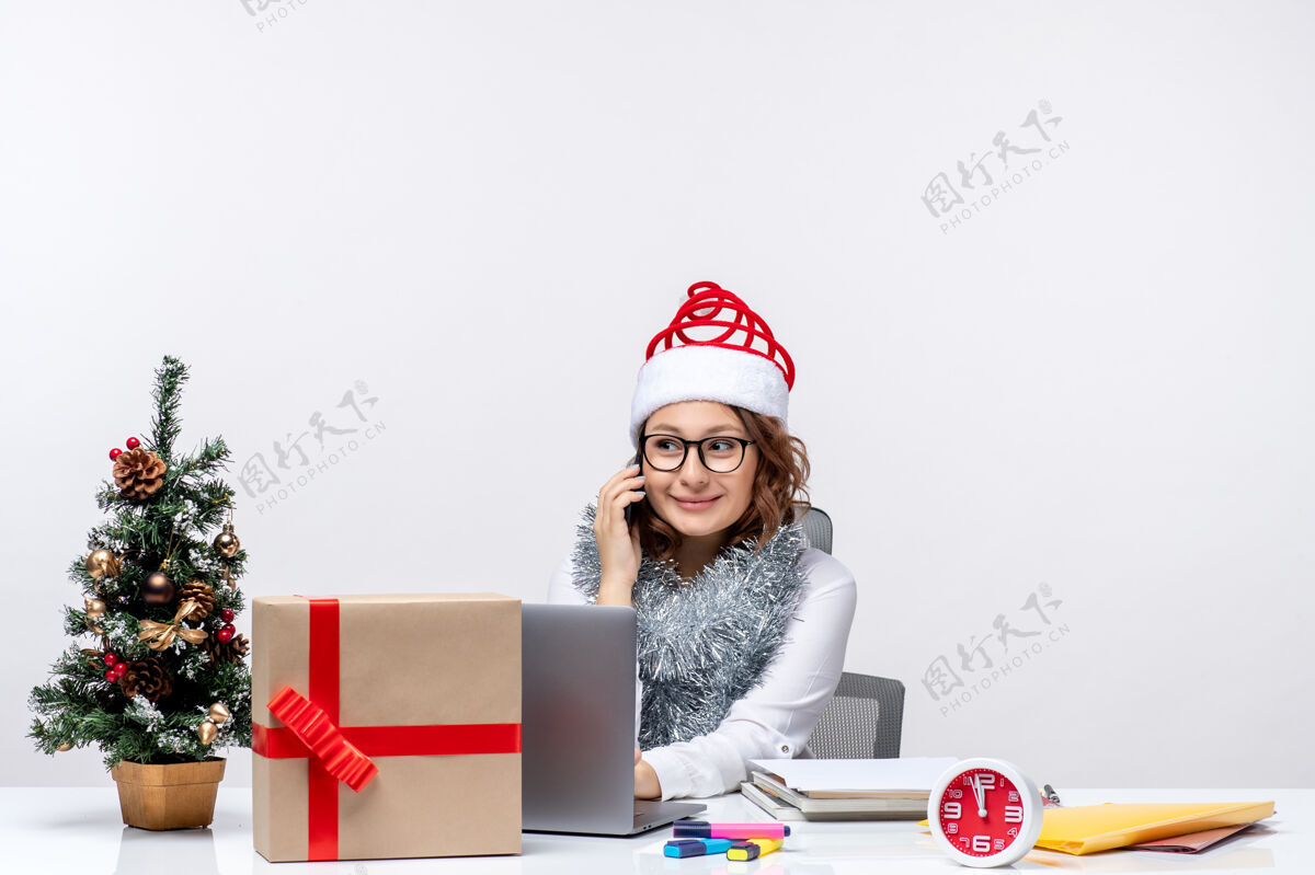 微笑前视图年轻女性在假日工作时使用白色背景的笔记本电脑圣诞节笔记本电脑女性